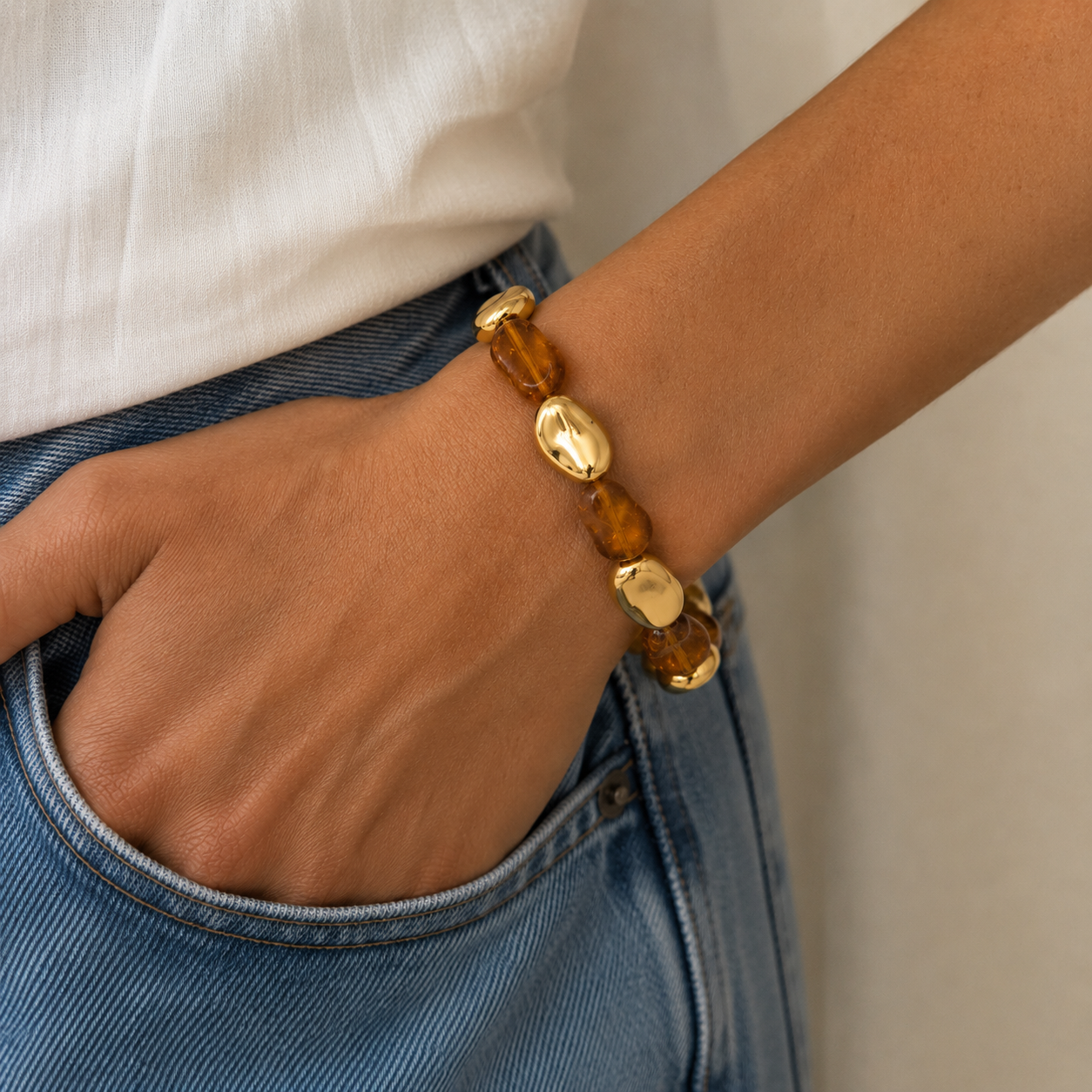 Bracelet galets ambre et or miroir porté au poignet - Dorée Paris